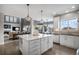 Well-appointed kitchen with island seating and stainless appliances offers seamless flow into dining and living areas at 26989 E Friend Pl, Aurora, CO 80016