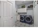 Convenient laundry room with modern appliances and stylish patterned flooring at 26989 E Friend Pl, Aurora, CO 80016