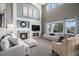 Cozy living room features a stone fireplace, comfortable seating, and a two-story vaulted ceiling at 26989 E Friend Pl, Aurora, CO 80016