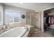 Serene main bathroom with a soaking tub, a glass shower, and a walk-in closet at 26989 E Friend Pl, Aurora, CO 80016