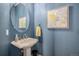 Charming powder room featuring an oval mirror and a blue color scheme at 26989 E Friend Pl, Aurora, CO 80016