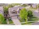 This aerial showcases a suburban home with a large driveway, mature trees, and a well-manicured lawn at 23870 E Dorado Pl, Aurora, CO 80016