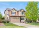 Charming two-story home with a manicured lawn, stone accents, and a two-car garage at 23870 E Dorado Pl, Aurora, CO 80016