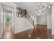 Entryway featuring a wood staircase with wrought iron spindles, hardwood flooring, and chandelier lighting at 23870 E Dorado Pl, Aurora, CO 80016