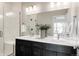 Modern bathroom featuring a double vanity, white tile shower, and sleek fixtures, offering a clean and contemporary space at 6307 Dayton Ct, Denver, CO 80238