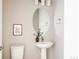 Stylish powder room featuring a pedestal sink, oval mirror, and clean, minimalist design for a modern look at 6307 Dayton Ct, Denver, CO 80238
