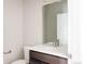 Modern bathroom with a sleek white countertop, dark wood vanity, and a large mirror reflecting the clean design at 6307 Dayton Ct, Denver, CO 80238