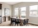 Bright dining room featuring a wood table with black chairs, chandelier, and large windows for abundant natural light at 6307 Dayton Ct, Denver, CO 80238