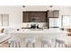 Modern kitchen featuring a large island with seating, stainless steel appliances, and dark cabinetry at 6307 Dayton Ct, Denver, CO 80238