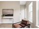 Comfortable living room area with a leather chair, neutral walls, wood floor, and lots of natural light at 6307 Dayton Ct, Denver, CO 80238
