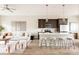 Open-concept living room and kitchen featuring a stylish island, modern furniture, and hardwood floors at 6307 Dayton Ct, Denver, CO 80238