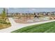 Community playground with play structures, climbing features, and seating, all surrounded by lush greenery at 6307 Dayton Ct, Denver, CO 80238
