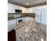 Well-lit kitchen boasts an island, granite counters, white cabinets and a full suite of appliances at 19193 E Amherst Dr, Aurora, CO 80013