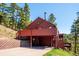 Exterior elevation showcasing a multi-level deck and convenient covered parking area at 7350 Timber Trail Rd, Evergreen, CO 80439