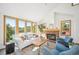 Bright living room with large windows framing views and a brick fireplace adding warmth at 7350 Timber Trail Rd, Evergreen, CO 80439