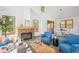 Open-concept living area featuring a brick fireplace and easy access to the dining space at 7350 Timber Trail Rd, Evergreen, CO 80439