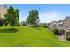 View of the backyard featuring a large grassy hill with some large trees and homes at 9278 W Ontario Dr, Littleton, CO 80128