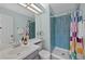 Bathroom featuring a walk-in shower with blue tile, light blue walls and an oval sink at 9278 W Ontario Dr, Littleton, CO 80128