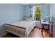 Bedroom featuring light blue walls, a bright window and light colored wood floors at 9278 W Ontario Dr, Littleton, CO 80128