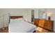 Comfortable bedroom featuring hardwood floors, large dresser, and a view into the Primary bath at 9278 W Ontario Dr, Littleton, CO 80128