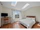 Bright bedroom featuring wood floors, skylights, desk space and light, natural light with leafy curtains at 9278 W Ontario Dr, Littleton, CO 80128