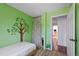 Green bedroom featuring a painted tree mural and floral curtain room divider at 9278 W Ontario Dr, Littleton, CO 80128