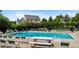 Great community pool featuring lounge chairs, picnic tables, and well-maintained hedges for privacy at 9278 W Ontario Dr, Littleton, CO 80128