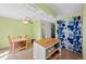 Bright dining area adjacent to kitchen, featuring a wooden table, stylish chairs, and a playful, colorful curtain at 9278 W Ontario Dr, Littleton, CO 80128