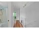 Hallway featuring wood floors with access to the bathroom, stairs, and other bedrooms at 9278 W Ontario Dr, Littleton, CO 80128
