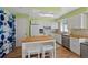 Charming kitchen features white cabinets, stainless steel appliances, and a kitchen island at 9278 W Ontario Dr, Littleton, CO 80128