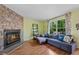 Cozy living room featuring a stone fireplace, comfortable seating, and a bright window at 9278 W Ontario Dr, Littleton, CO 80128