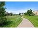 Picturesque community walking path through the neighborhood with lush green lawns and mature trees at 9278 W Ontario Dr, Littleton, CO 80128