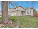 Attractive two-story home featuring a well-manicured lawn, a stone-accented facade, and a welcoming entrance at 12047 W Coal Mine Dr, Littleton, CO 80127