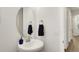 Stylish half bathroom with a modern circular mirror, brushed nickel fixtures, and a sleek sink at 27986 E Frost Pl, Aurora, CO 80016
