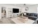 Cozy living room with gray carpet, a comfortable sectional, and built-in shelving for display at 27986 E Frost Pl, Aurora, CO 80016