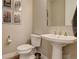 Half bathroom featuring vintage posters, sink with chrome fixtures, and toilet at 11142 Bright Sky St, Littleton, CO 80125