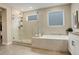 Modern bathroom with soaking tub, glass shower, and tiled floors and walls at 11142 Bright Sky St, Littleton, CO 80125