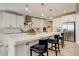 Modern kitchen featuring a marble countertop island with barstool seating, sleek white cabinets, and stainless steel appliances at 11142 Bright Sky St, Littleton, CO 80125