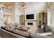 Open-concept living room with soaring ceilings, stone fireplace, and large sofa under a modern chandelier at 11142 Bright Sky St, Littleton, CO 80125