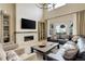 Elegant living room featuring a stone fireplace, built-in shelving, and large windows with neutral drapes at 11142 Bright Sky St, Littleton, CO 80125