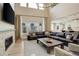 Open living room with soaring ceilings, fireplace, oversized sectional, and large windows with natural light at 11142 Bright Sky St, Littleton, CO 80125