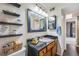 Bathroom featuring a black granite vanity, modern lighting, and floating shelves at 3325 S Ammons St # 4-206, Lakewood, CO 80227