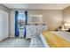 Bedroom with plush carpeting, a large dresser, and a sunny window with blue curtains at 3325 S Ammons St # 4-206, Lakewood, CO 80227