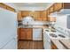 Functional kitchen with white appliances, warm wood cabinets, and efficient layout for easy cooking at 3325 S Ammons St # 4-206, Lakewood, CO 80227