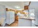 Efficient kitchen with wood cabinets, white appliances, and breakfast bar seating area at 3325 S Ammons St # 4-206, Lakewood, CO 80227
