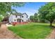 Spacious backyard with a deck, green lawn, and mature trees on a sunny day at 7171 Canyon Way, Frederick, CO 80504