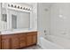 Bright bathroom featuring a dual sink vanity and a tiled tub and shower at 7171 Canyon Way, Frederick, CO 80504