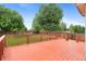 Red wooden deck overlooking a well-maintained lawn and backyard at 7171 Canyon Way, Frederick, CO 80504