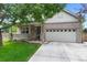 Inviting brick home featuring a covered porch, attached two-car garage, and neat landscaping at 7171 Canyon Way, Frederick, CO 80504