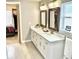 Bathroom featuring a double sink vanity, marble countertops, and updated lighting at 2525 S Pennsylvania St, Denver, CO 80210